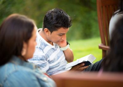 Young man reading scriptures outside